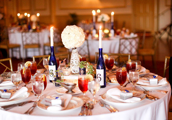 Rusztikus hangulatú esküvőhöz szépen mutatnak a kék palackok és az egyszerű fehér gyertyák.