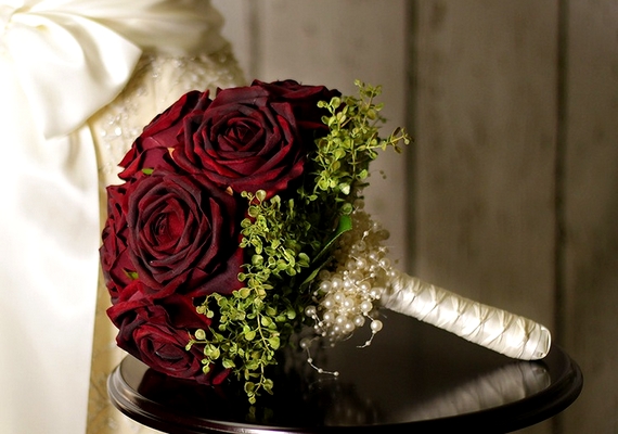 Sokat emelhetsz a dekoráció színvonalán, ha a kezedben is bordó rózsacsokor van.