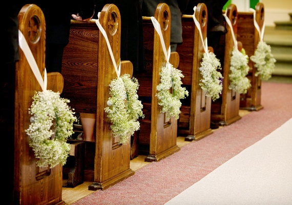 Templomi esküvő esetén ideális lehet a padsorok oldalára erősített koszorú.